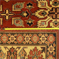 Afghan Gazni Kazak rug, the hand-knotted wool pile featuring a rust red ground with all-over geometric floral motifs in ivory and dark green, enclosed by a wide ivory border with stylised rosettes and angular vine decoration, fringed ends, from the region of Ghazni, Afghanistan