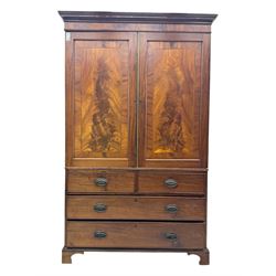 Early 19th century mahogany linen press cupboard, projecting moulded cornice over figured frieze, two panelled doors enclosing shelves, fitted with two short and two long cock-beaded drawers, on bracket feet 