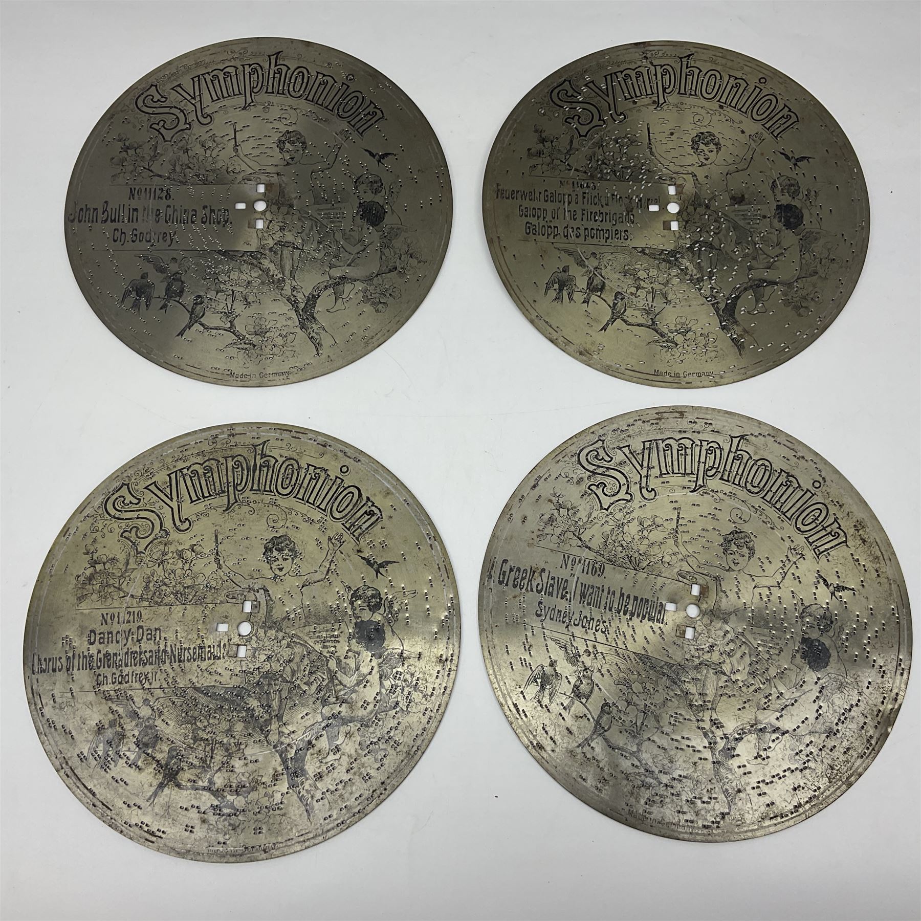 Late 19th century Symphonion disc musical box for spares or repair, inlaid walnut case with front lever action, playing 25.5cm discs on a 10.5cm steel comb with forty-nine teeth, musical scene of cherubs under the lid, L33cm; together with twelve 25.5cm discs