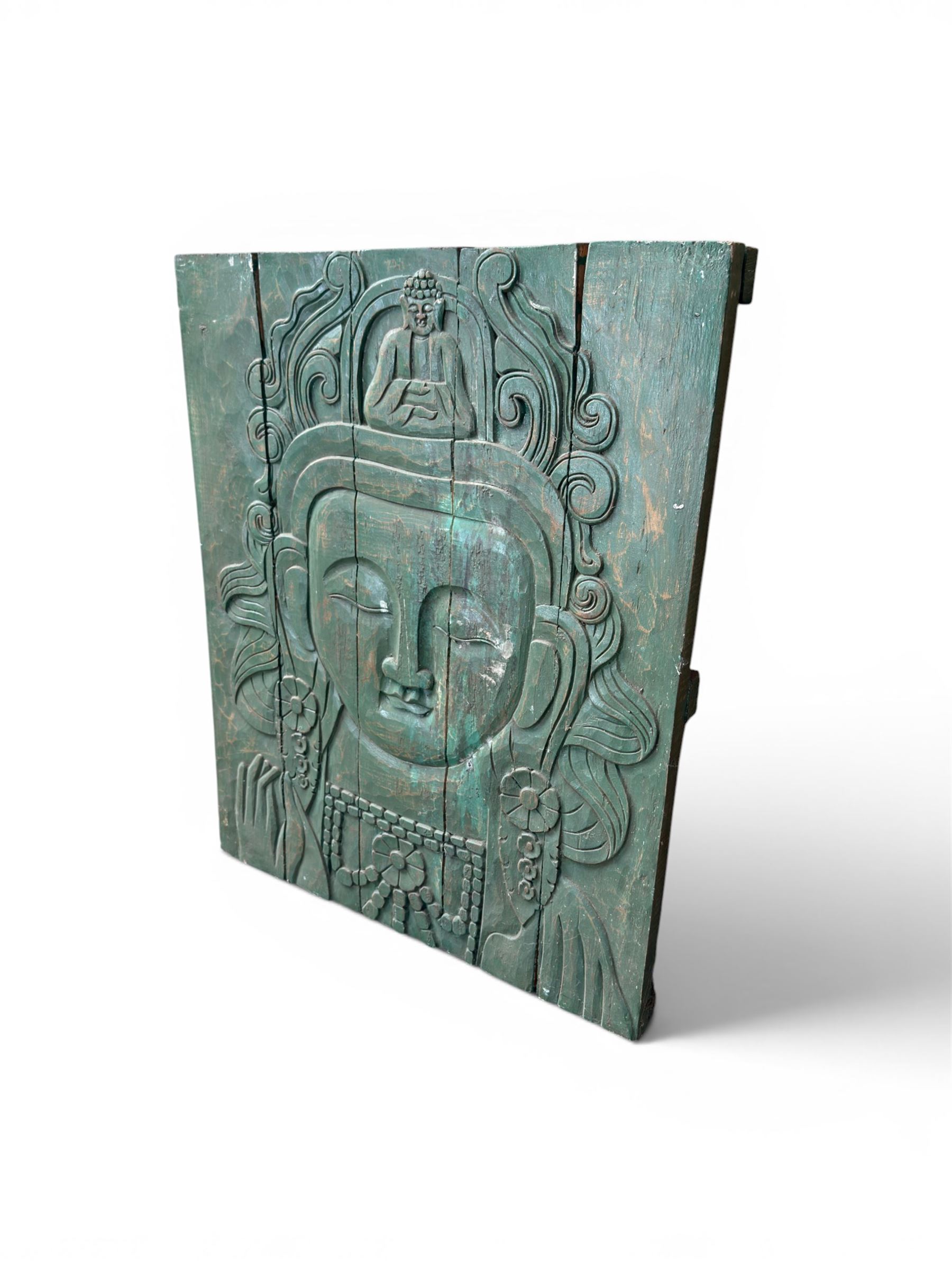 Pair of South East Asian carved wooden panels, depicting Buddha or Deity faces