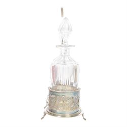 Late 19th century silver plated Silber & Fleming triple decanter stand, the three cut glass decanters with spire stoppers housed within foliate and scroll pierced bottle sleeves, upon a tripart base with six scroll feet, the base mounted with articulated x-frame curved handle, including handle when positioned upright H35.5cm, W34cm