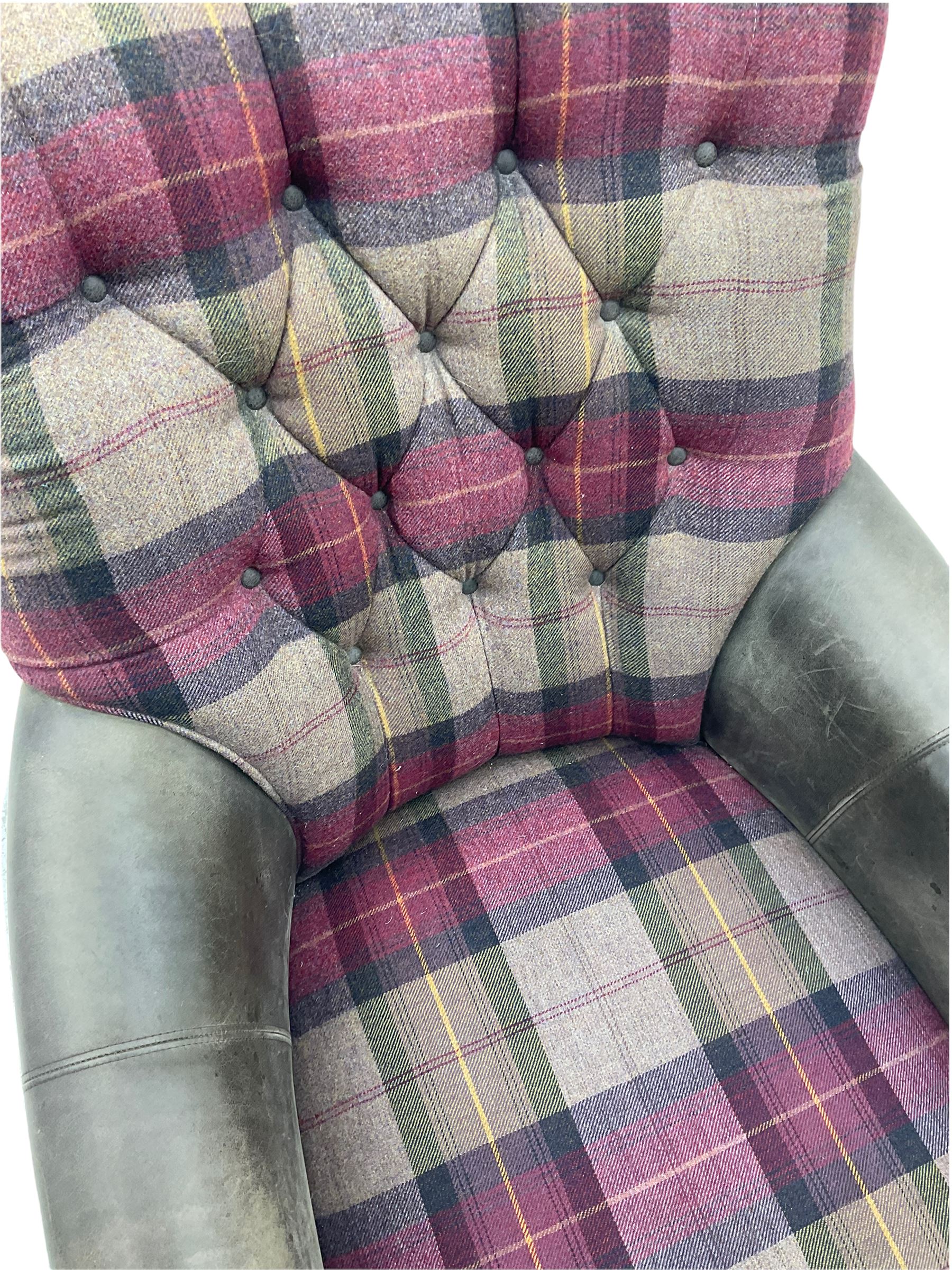 John Sankey - low armchair, buttoned back upholstered in tartan patterned fabric with contrasting grey leather, raised on turned and ebonised front feet with brass and ceramic castors, with matching foot stool
