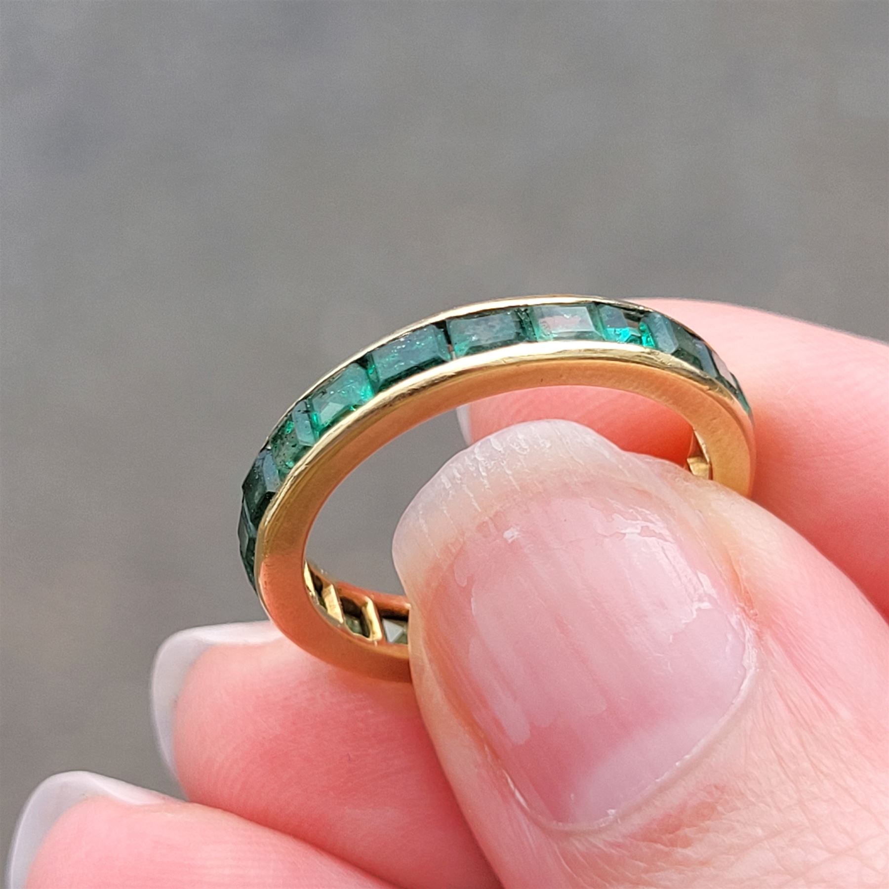 18ct gold emerald full eternity ring, channel set with calibre cut emeralds