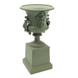 20th century green painted cast iron campana urn on plinth, gadroon moulded rim, the body with mask and scrolled cartouche mounts, on square plinth with moulded skirt