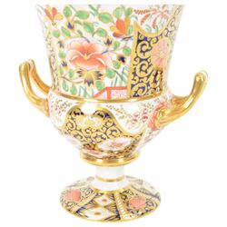Royal Crown Derby campana vase, decorated in imari pattern, with gilt handled upon a circular base, with mark beneath, H22cm