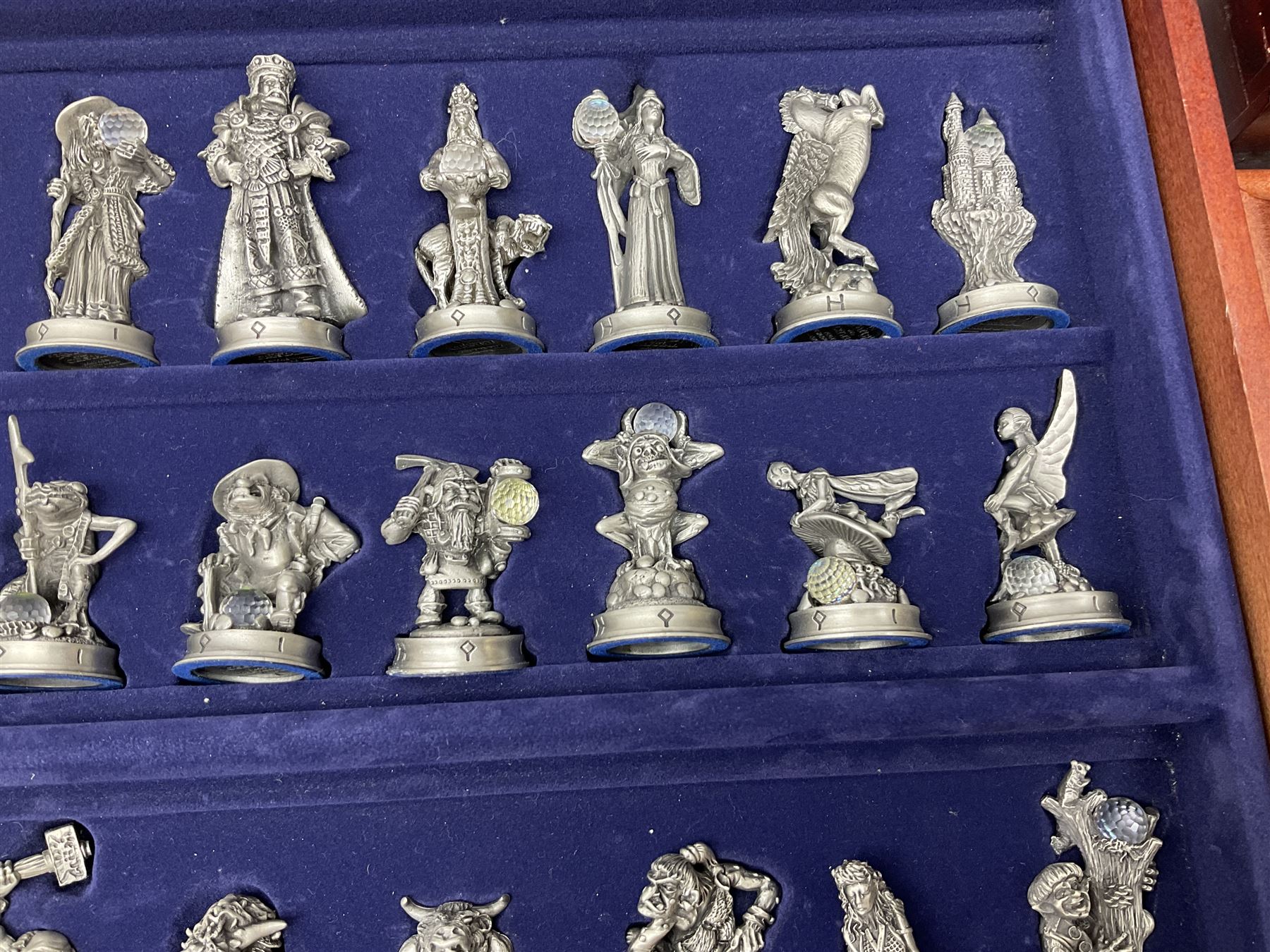 Danbury Mint 'The Fantasy of the Crystal' chess set consisting of mythical pewter chess pieces within a wooden case with chess board lid, together with 16 additional chess pieces in a wooden display case.
