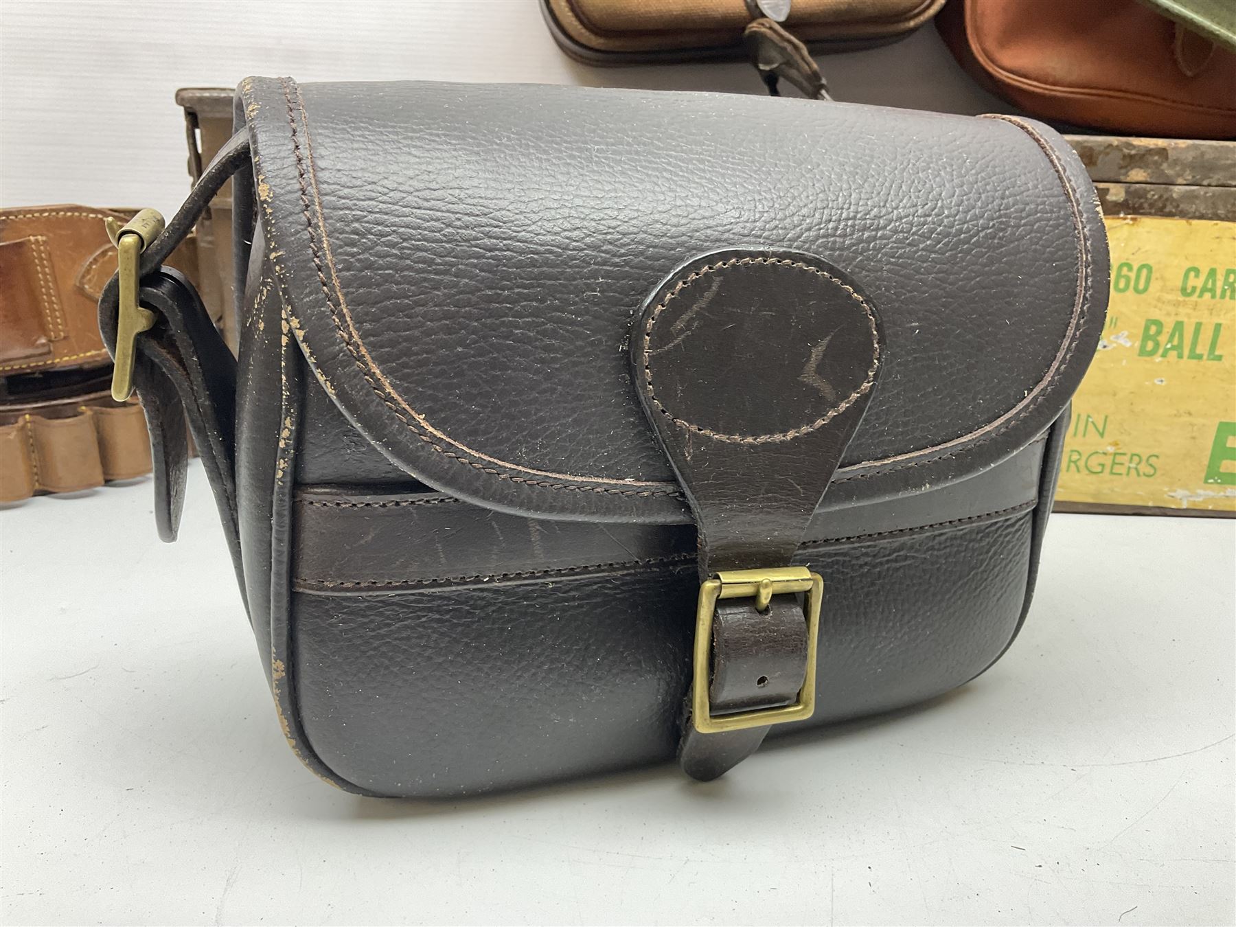 Miscellaneous shooting accessories - W.J. Bowman & Sons clay pigeon launcher; two leather cartridge belts; three cartridge bags; two canvas/leather game bags; and two metal/wooden cartridge boxes