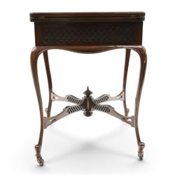 Edwardian carved mahogany envelope card table, the rectangular quadruple hinged top enclosing baize-lined interior, the single frieze drawer and sides with blind-fretwork carving, over cabriole supports with scroll feet and castors united by pierced lattice fretwork X-stretcher with turned finial