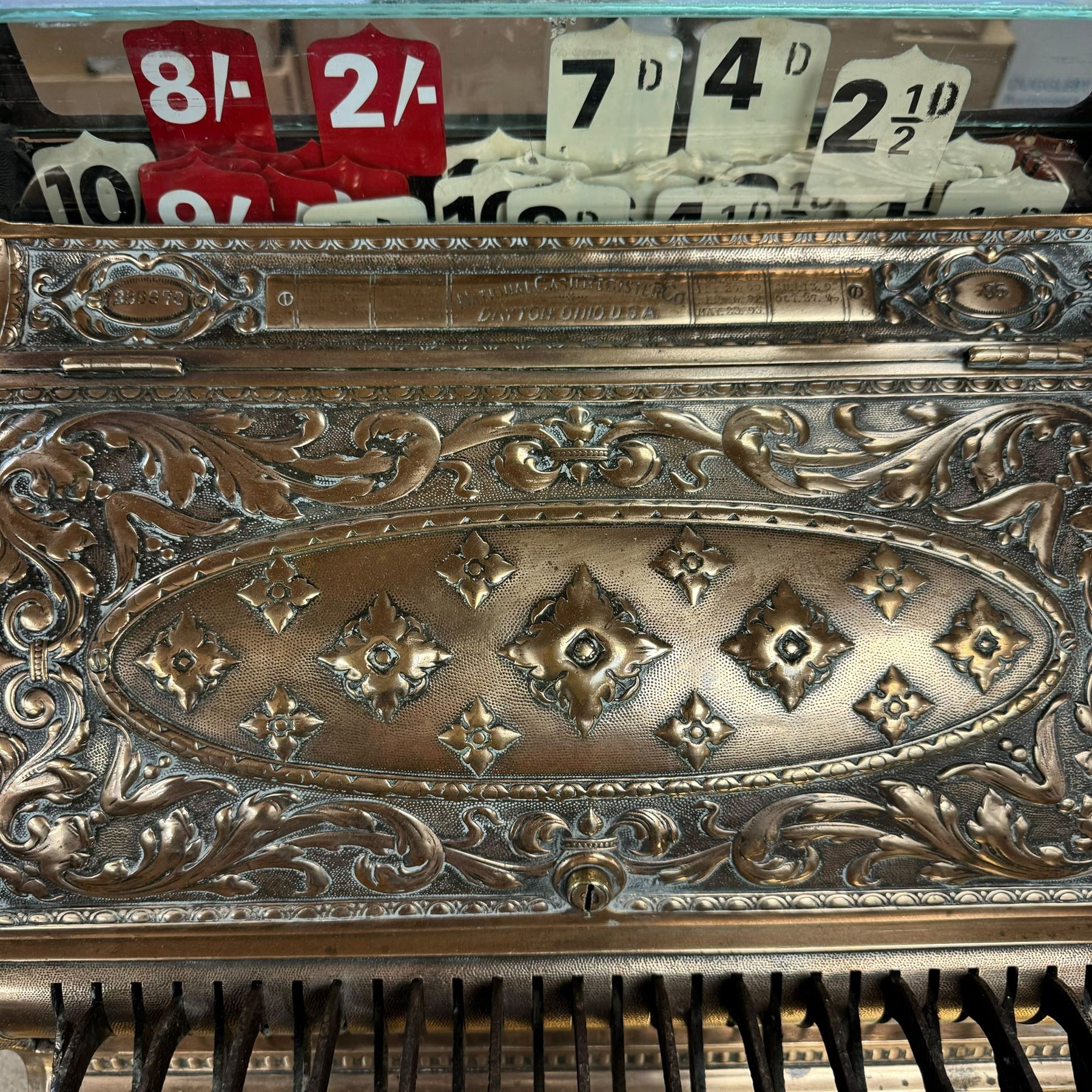 Early 20th century copper and brass till, embossed throughout with relief floral and acanthus leaf decoration, made by The National Cash Register Company Dayton Ohio USA, H46cm