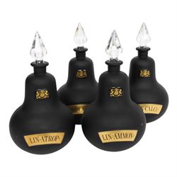 Set of four 20th century Royal Pharmaceutical Society black frosted glass bottles, of bellied form with clear cut glass spire stopper, each body bearing gilt label in Latin: LIN:AMMON:, LIN:ATROP:, LIN:CAMPH:, and LIN:CALCi:, and gilt Royal Pharmaceutical Society crest to neck, H25cm

Provenance: From the collection of the family of Peter Green, a practising pharmacist whose career spanned the mid to late 20th century. During his professional life he managed pharmacies in Yeovil, Somerset, and later Selles Chemist in Filey, North Yorkshire, before purchasing and running his own business, Peter Green Pharmacy, located in the Market Place, Malton. The bottles were displayed as part of the traditional shop fittings in both the Filey and Malton pharmacies and were retained as part of his collection.