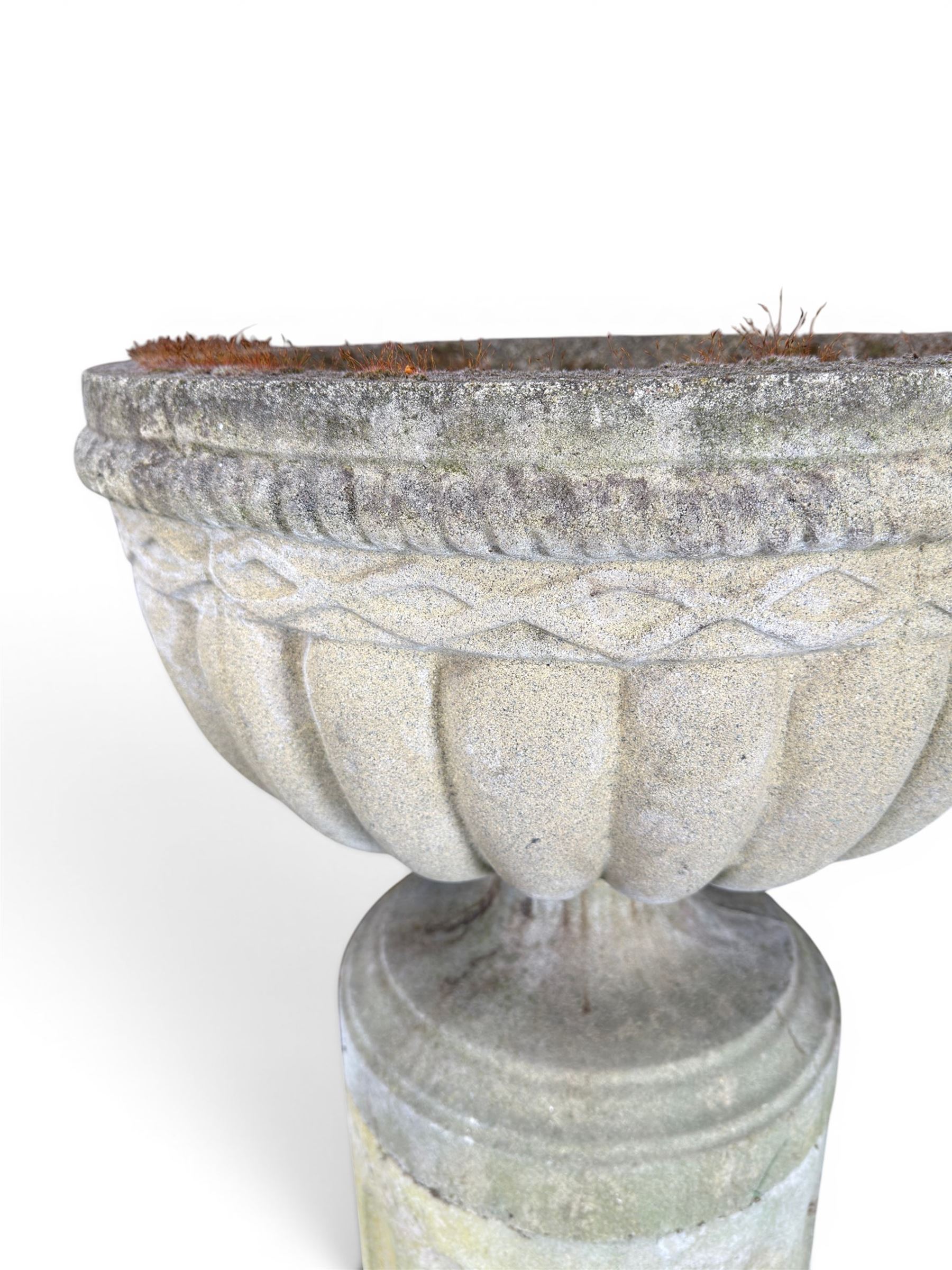 Four 20th century good quality weathered cast stone pedestal urns, circular lobed bowls with rope twist and lattice border, raised on squat base with fluted columns