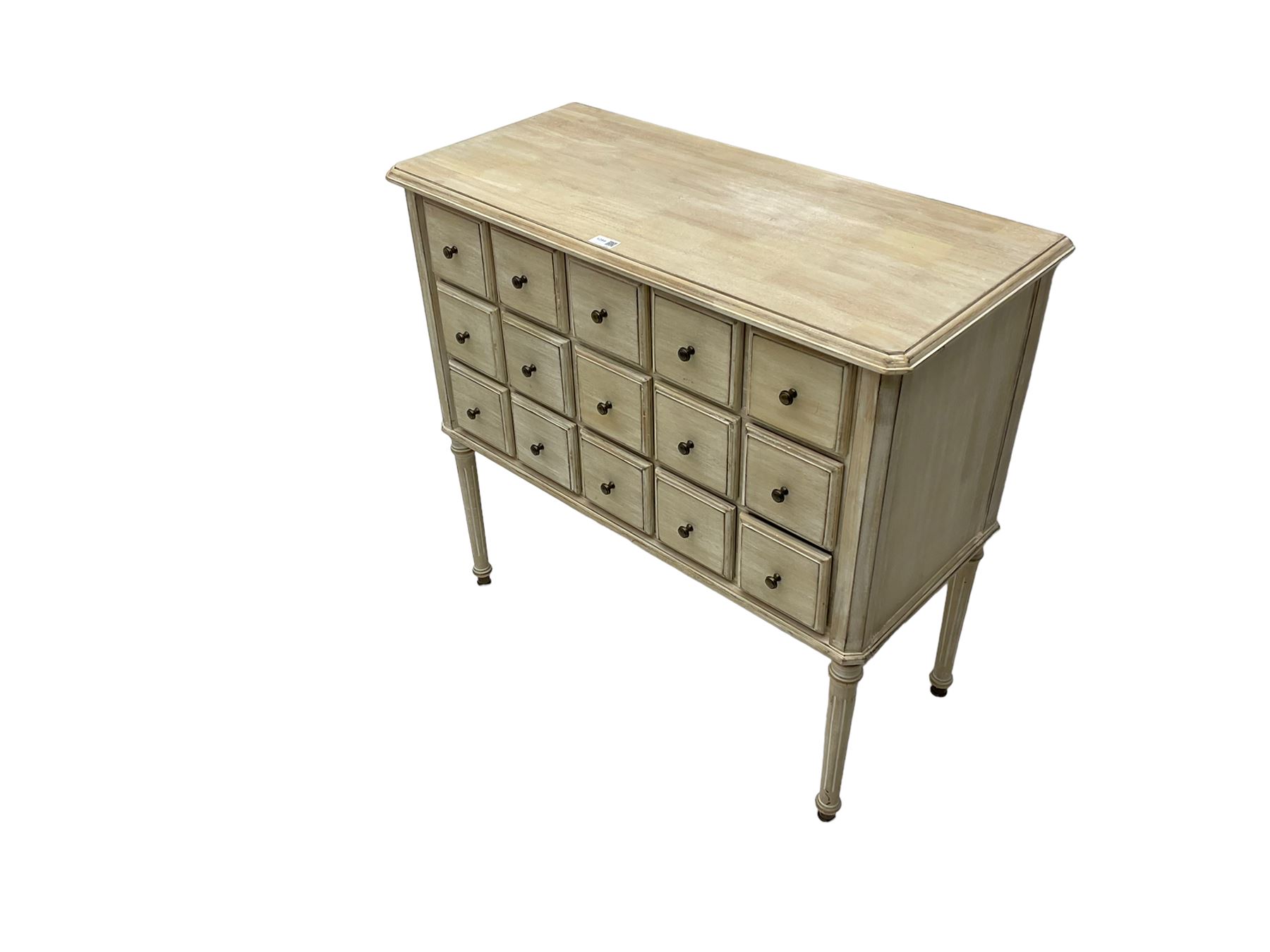 Washed finish pigeon hole or apothecary style chest, fitted with fifteen drawers, raised on fluted tapered supports 
