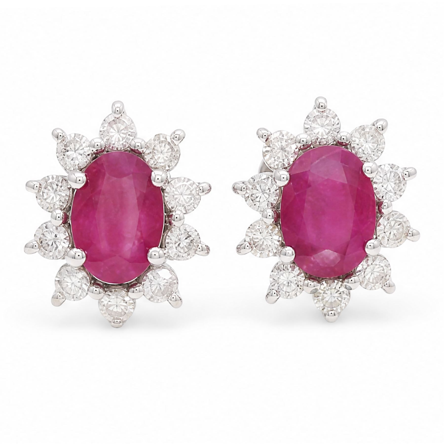 Pair of 18ct white gold ruby and diamond earrings, each stud set with a single oval cut ruby and surrounded by ten round brilliant cut diamonds, stamped, total ruby weight approx 1.40 carat, total diamond weight approx 0.60 carat