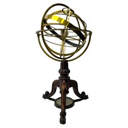 19th century brass terrestrial armillary sphere on rosewood base, lobe carved column on three splayed supports with scrolled carved terminals, the supports united by circular compass with turned stretchers