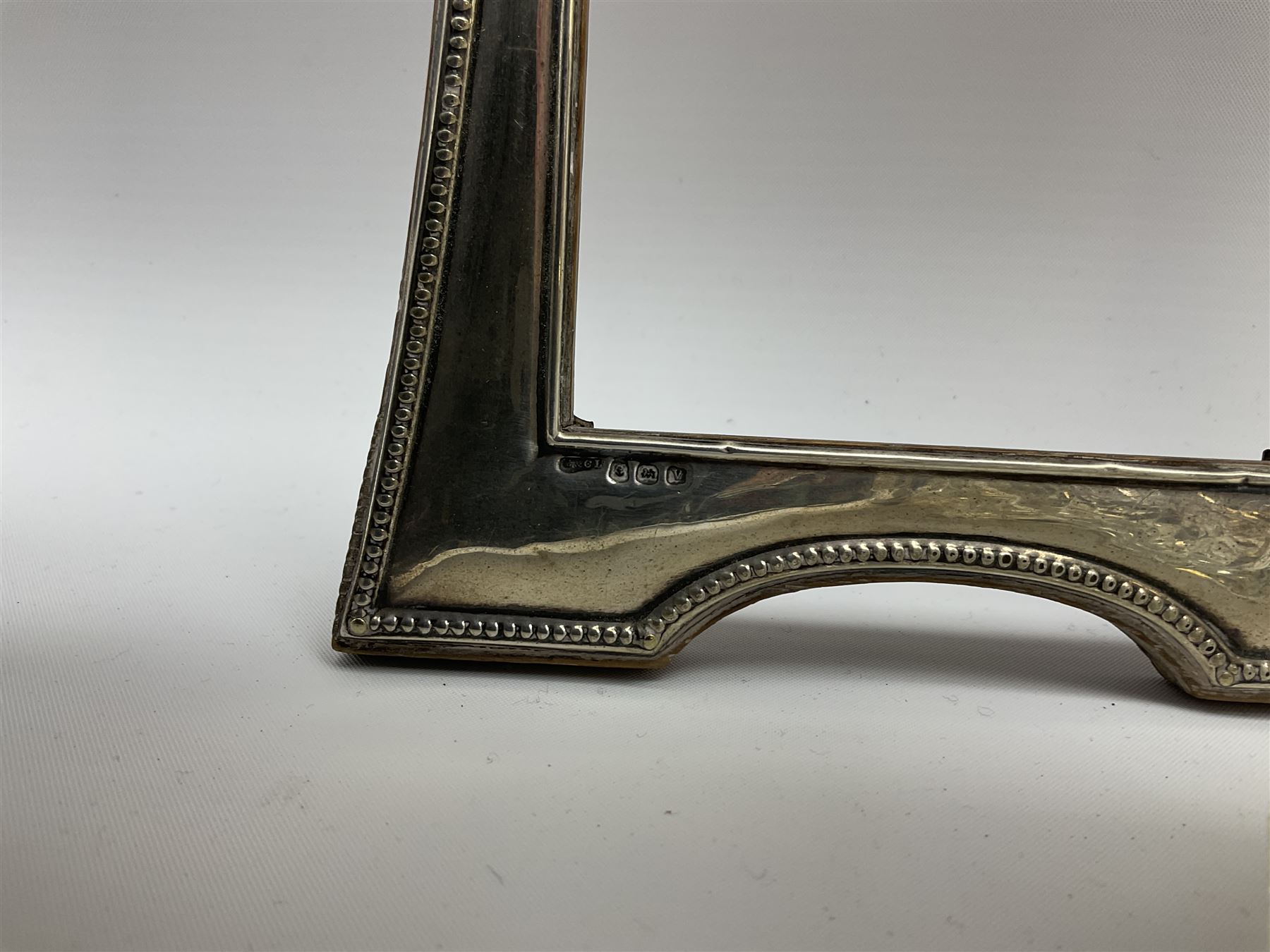 Clear glass decanter of slender oviform with silver collar stamped MN & WB 925, Mappin & Webb, together with an early 20th century silver photo frame hallmarked G & C Ltd of Birmingham, two clear glass shakers with pierced silver tops and silver collared glass storm lampshade with etched decoration, tallest H37.5cm