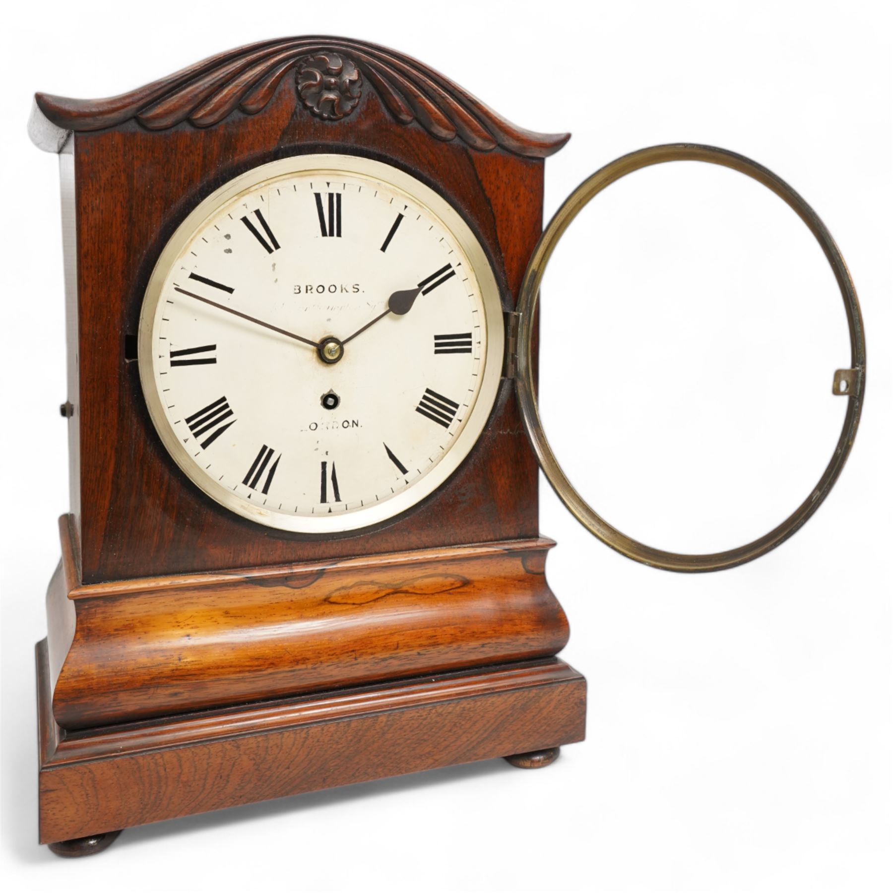 Brooks of London- Regency 8-day rosewood bracket clock c1825, with a serpentine shaped pediment and foliate carving on an ogee stepped base with bun feet, 8