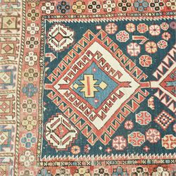 Vintage Caucasian Shirvan hand-knotted rug, indigo field with an arrangement of geometric diamond medallions and stylized tribal motifs within multiple patterned borders, with fringe ends 