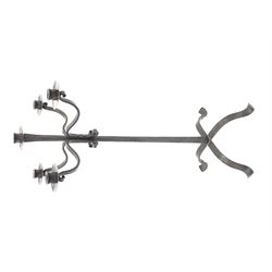 Wrought hand forged iron candle stand, four scrolled branches and central vertical branch with sconces, tapered column on four shaped and out splayed supports