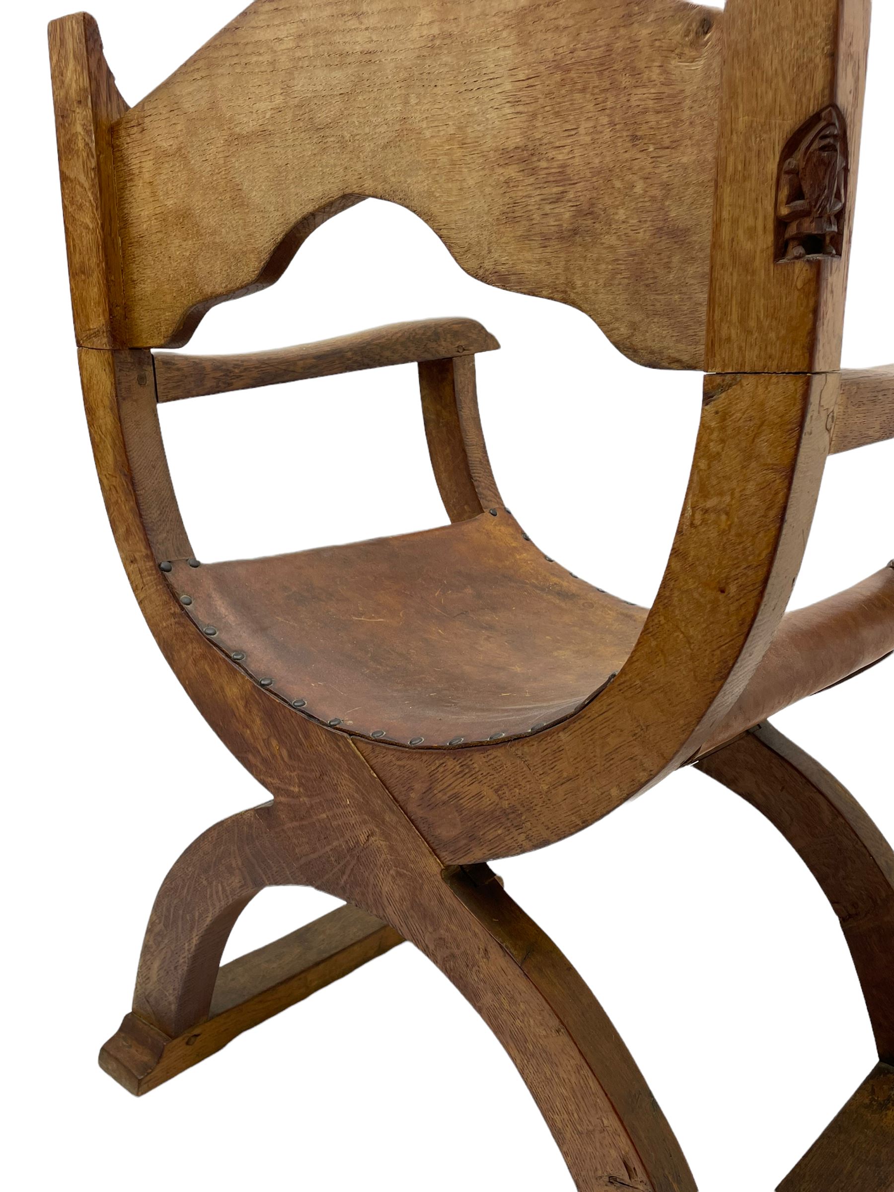 'Gnomeman' oak curved x-framed throne chair, sloped arched cresting rail carved with arcade, studded slung leather seat, the supports joined by sledge feet, rear upright carved with gnome signature, by Thomas Whittaker of Littlebeck