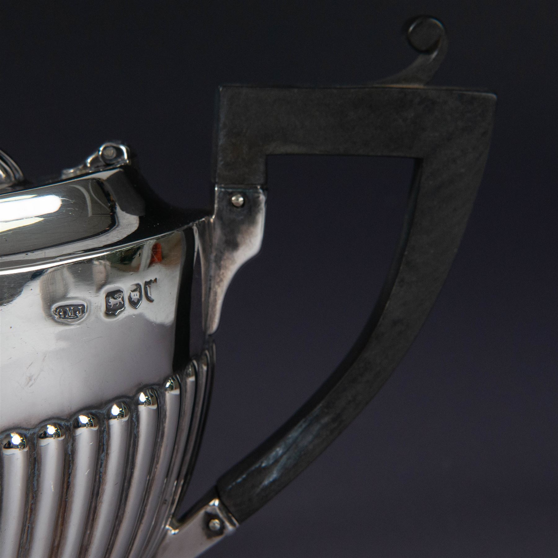 Victorian silver two piece bachelors tea service, comprising teapot and milk jug, of oval part fluted form, the teapot with ebonised wooden handle and finial, hallmarked Josiah Williams & Co, London 1895, together with a silver milk jug and open sucrier, of similar form, hallmarked William Hutton & Sons, London 1898