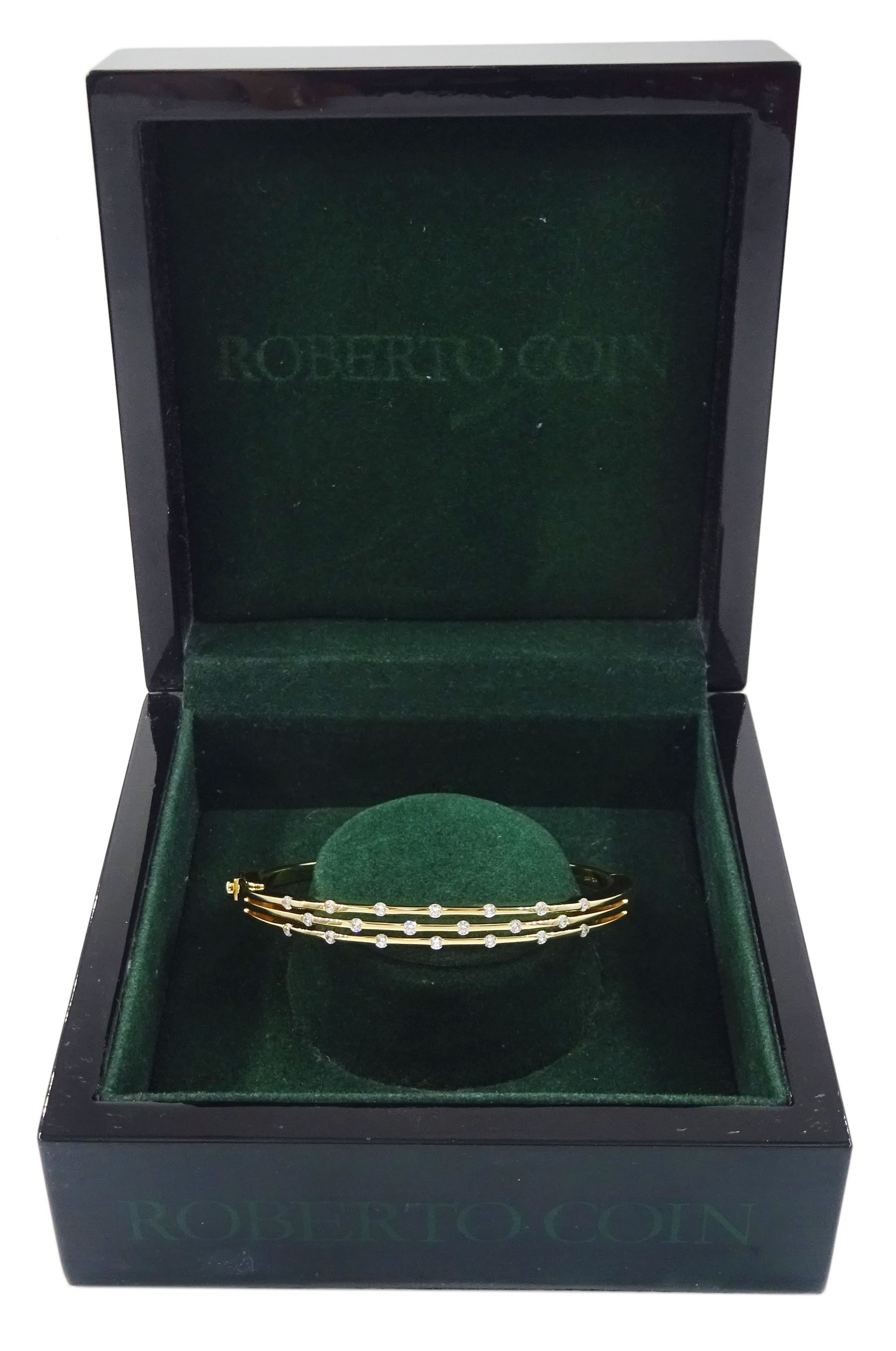 Roberto Coin 'Parisienne' 18ct gold three row round brilliant cut diamond bangle, with a signature round cut ruby to the underside and ruby set clasp, Birmingham 2006, boxed