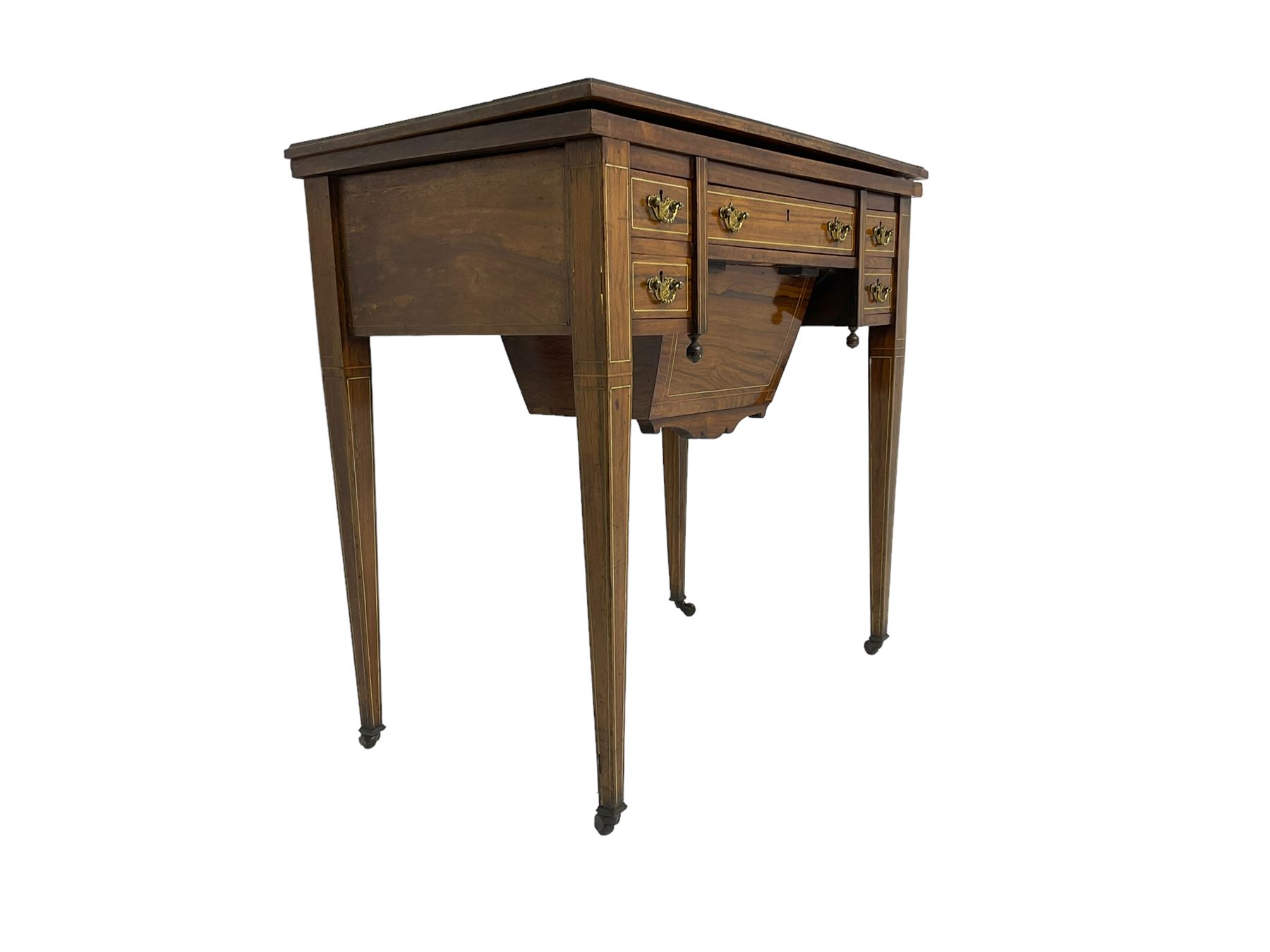 Edwardian inlaid mahogany games or work table, rectangular fold-over top inlaid with stylised dragon ivorine decoration and stringing, fitted with one long flanked by four small drawers over sewing compartment drawer, raised on square tapering supports with castors