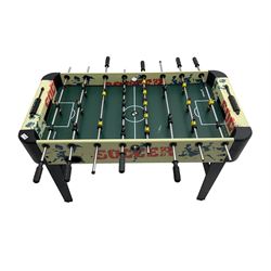 Sportcraft table football game raised on supports with stretcher
