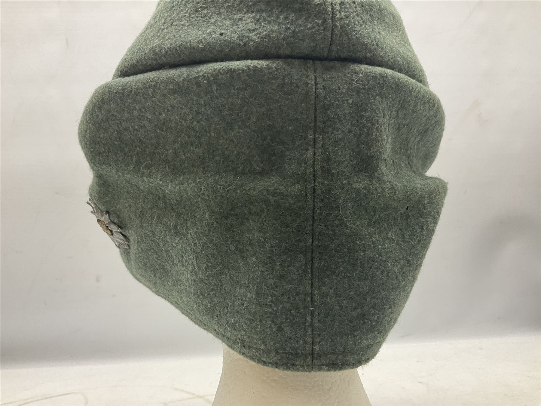 WW2 German Army M43 field cap with triangular cloth eagle and roundel badge and metal edelweiss badge for mountain troops; faintly stamped '5 VMF(?)'