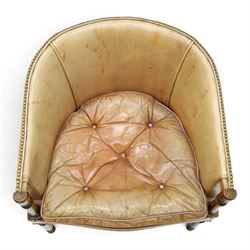 Early 20th century Georgian design mahogany framed desk or club armchair of tub form, with turned pilaster arm supports and legs with rear splayed supports, upholstered in faded tanned leather with loose seat cushion