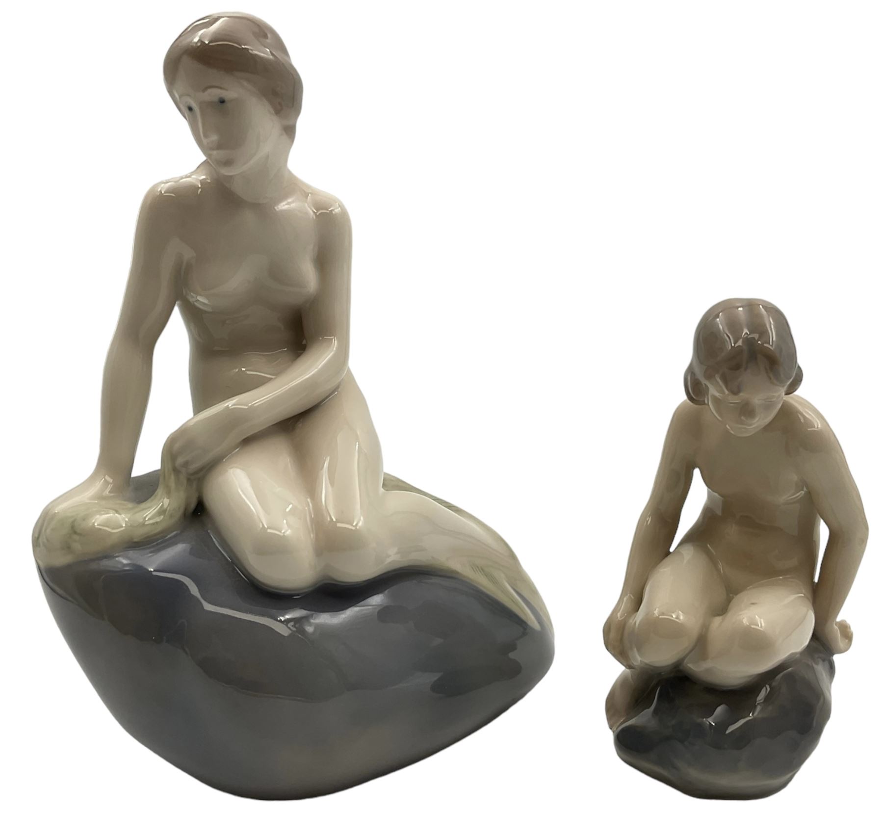 Two Royal Copenhagen figures, comprising The Little Mermaid, modelled by Edvard Eriksen, no. 4431 and Royal Copenhagen girl on stone no 4027, Little Mermaid H22cm