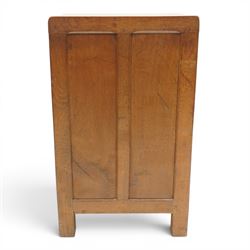 Mouseman - early-to-mid-20th century adzed and panelled dark oak bedside cupboard, raised back over rectangular canted top, fitted with single panelled cupboard door with chamfered rails and wrought iron fittings, enclosing two adjustable shelves, raised on canted square feet, carved with mouse signature, by the workshop of Robert Thompson of Kilburn