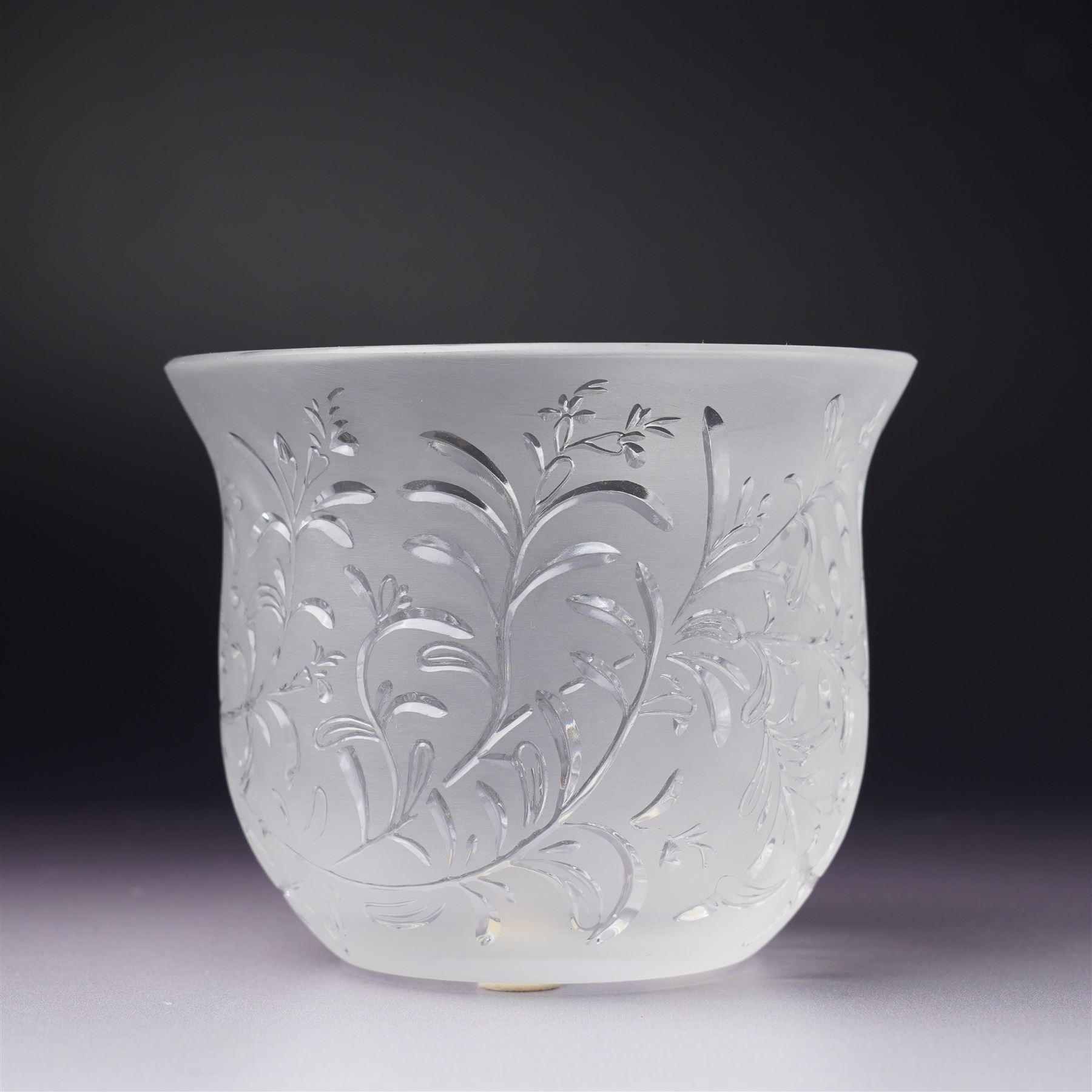 Three Lalique frosted glass tea light holders, decorated with the coriander and basil patterns, and another with trailing leaves, marked Lalique France to base, H7.5cm