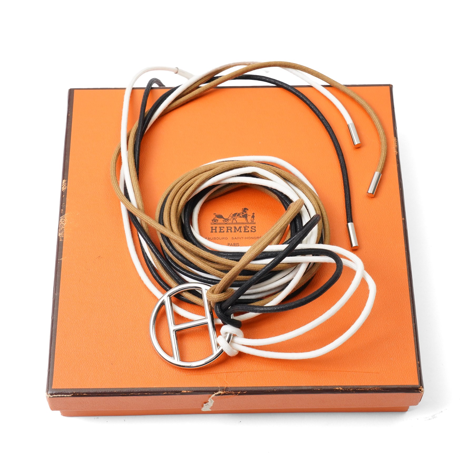 Hermès - long multi-cord belt in black, white and camel, suspending a large palladium-tone circular openwork H pendant, signed HERMES, in original box