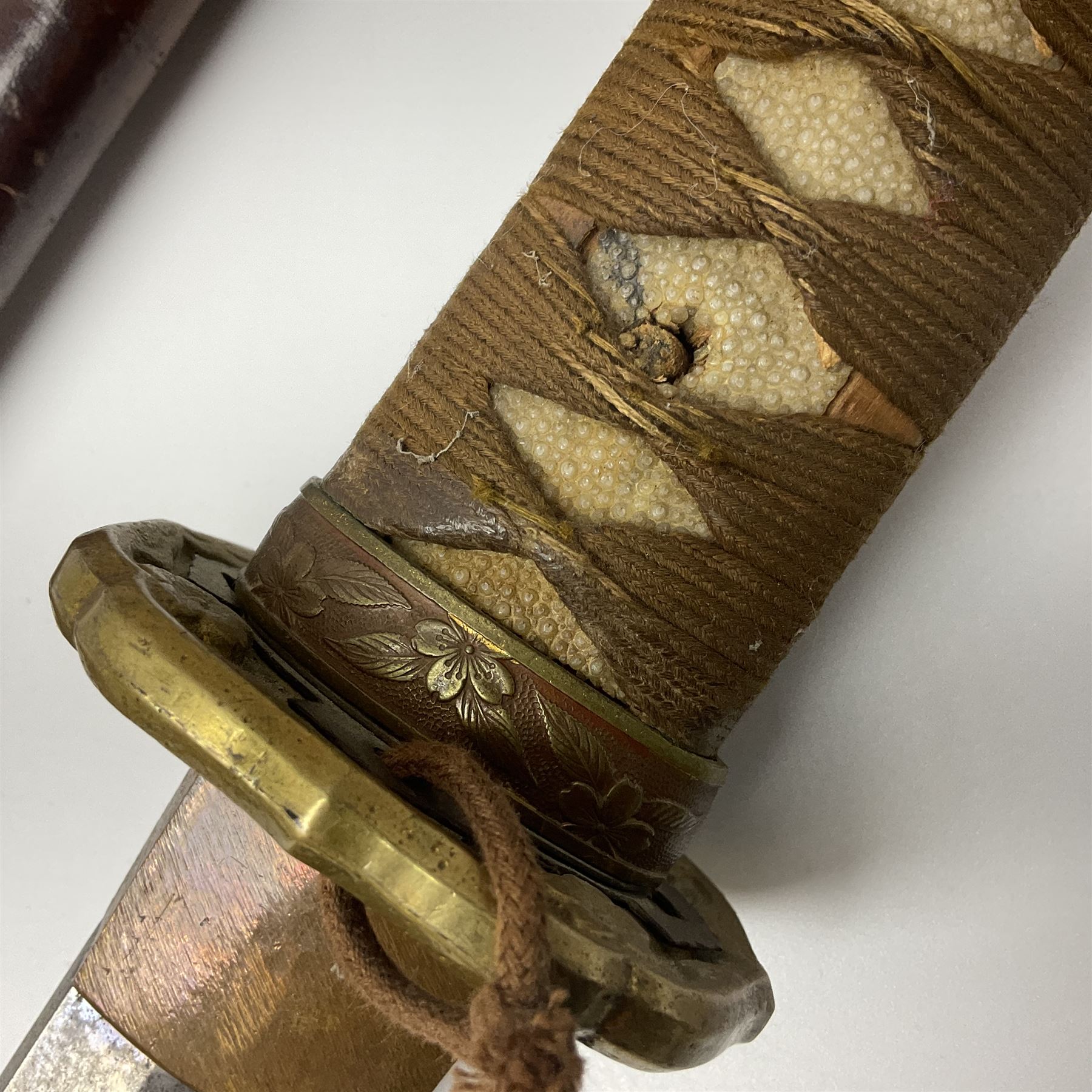 WW2 Japanese Army officer's shin gunto/katana sword with 67cm steel single edged blade, foliate cast brass tsuba, bound fish-skin grip with brass mounts, inscribed and painted marks to tang; in lacquered wooden scabbard with leather combat covering bearing four character marks L99cm overall