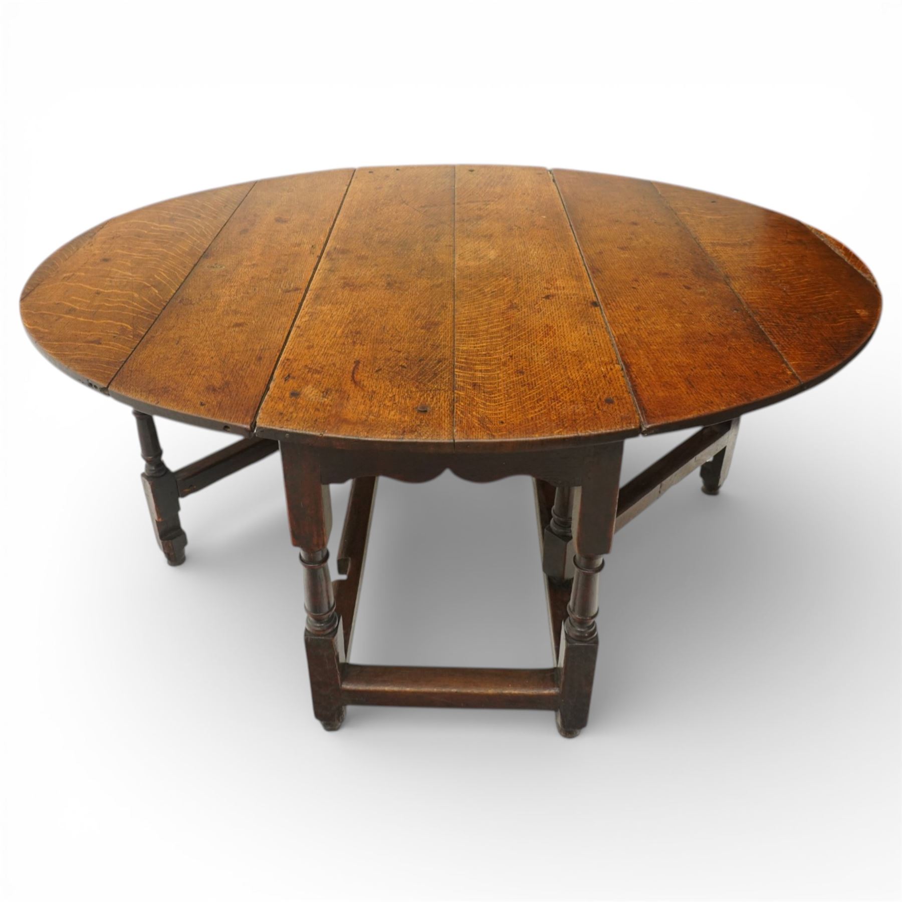 18th century large oak gateleg table, of plank top construction with visible dowels, with drop leaves to form an oval table 167cm in width, raised on block and turned supports