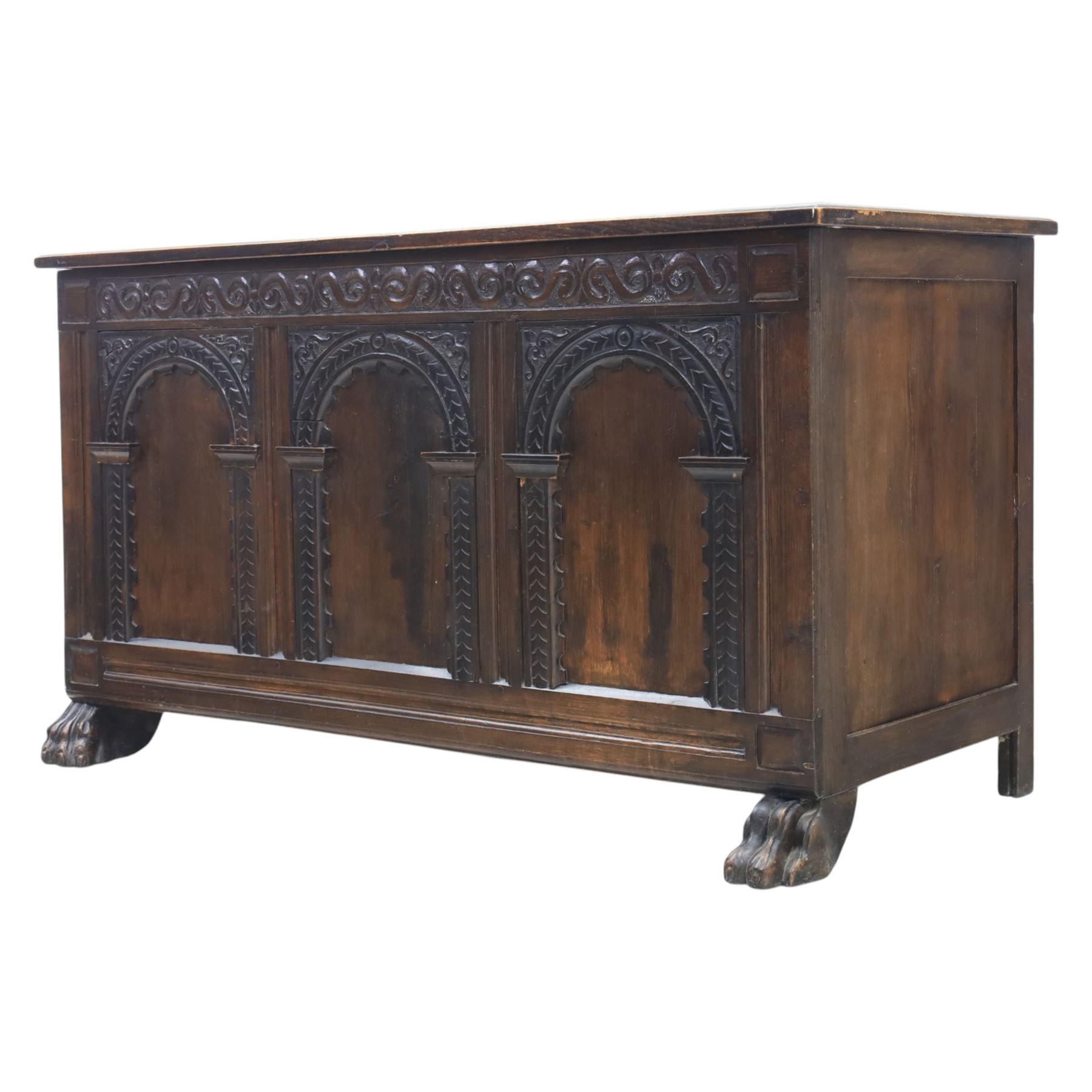 17th century design panelled oak blanket chest, hinged top above carved triple arch frieze, raised on individual carved claw feet