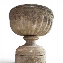 20th century good quality weathered cast stone pedestal urn of ecclesiastical design, circular lobed bowl with rope twist and lattice border, raised on squat base with fluted column  and acanthus decorated base