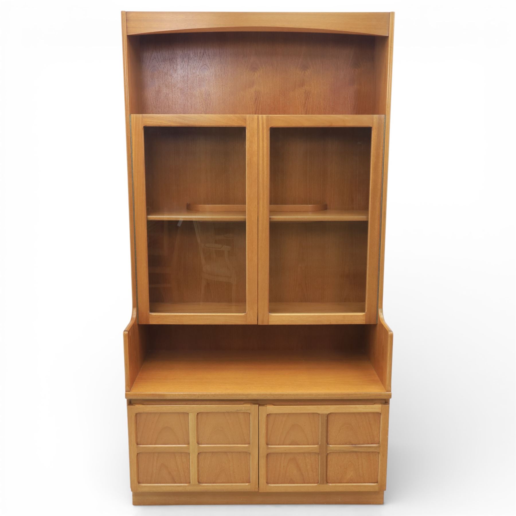 Nathan - teak wall unit, the arched open display recess above a glazed cabinet enclosed by two cupboard doors fitted with internal shelving, the lower section with a recessed serving surface over a pair of signature square panelled cupboard, raised on an integrated plinth base