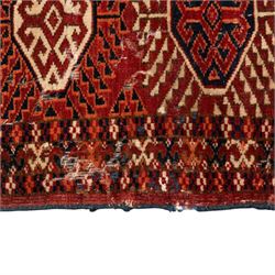 Persian Bokhara crimson ground rug, the field decorated with five rows of repeating Gul motifs with interspersed geometric design, enclosed by a guard band of further geometric-style Gul designs comprised of hook motifs