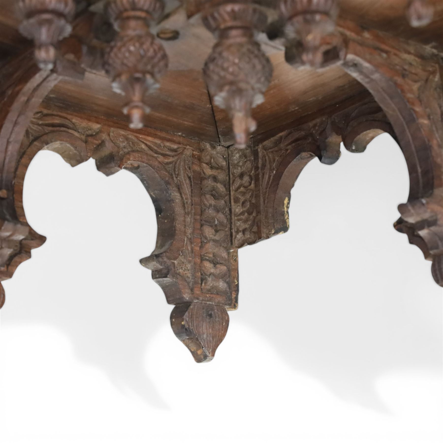 20th century Indian carved hardwood corner shelf, the tiered pagoda form with pierced and carved foliate panels centred by figural carving, supported by turned and carved columns, with shaped brackets and pendant finials
