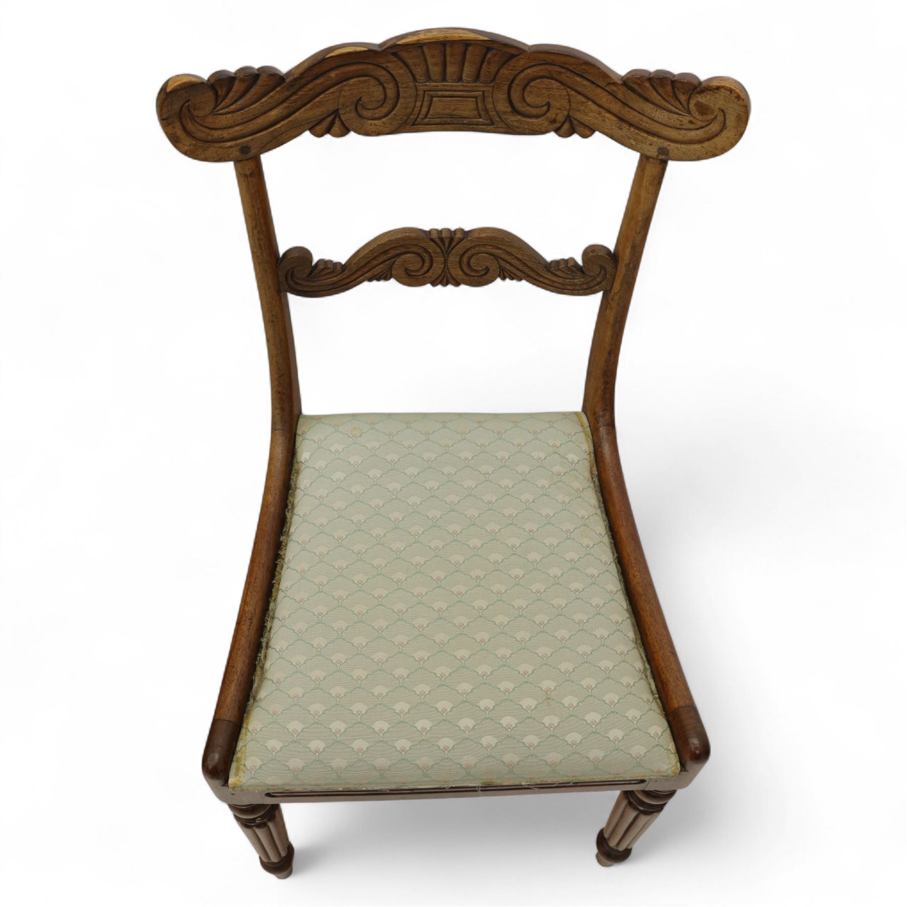 Set of four 19th-century rosewood dining chairs in the William IV style, shaped and carved top rail with fan and scroll decoration above a upholstered padded seat on reeded and turned front legs 