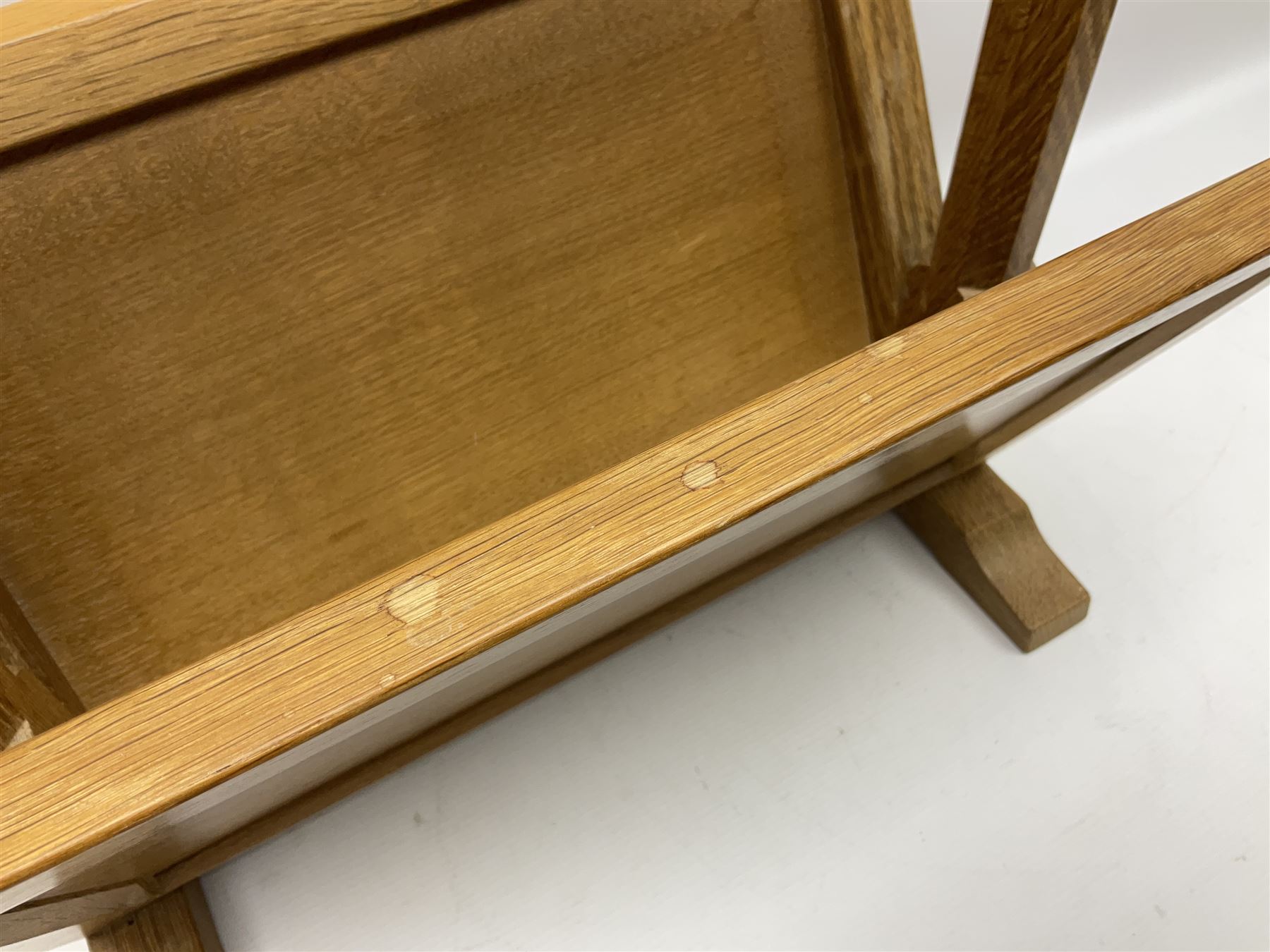 Mouseman - oak magazine rack, the top rail pierced with handle and carved with mouse signature, octagonal supports with two panelled and splayed sides, on sledge feet, by the workshop of Robert Thompson, Kilburn 