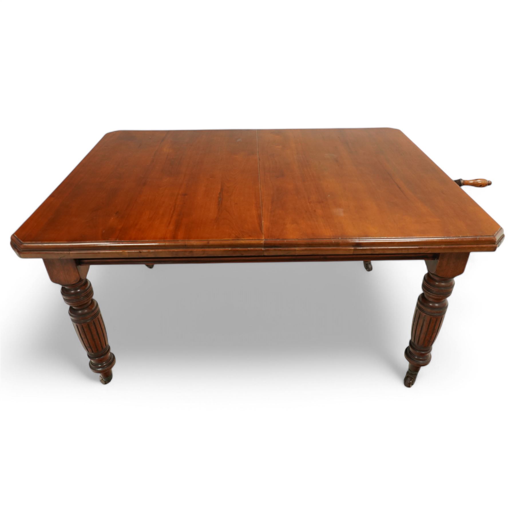 Late Victorian mahogany extending dining table with two leaves, moulded chamfered edge above, turned and reeded legs and ceramic castors, winding handle included, 205cm extended, 132cm closed, 102cm wide, 73cm high