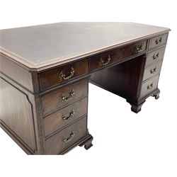 Large Georgian design mahogany twin pedestal partner's desk, moulded rectangular top with canted corners and inset leather writing surface, fitted with nine drawers and two cupboards, the pedestals with canted uprights decorated with blind fretwork, on ogee bracket feet