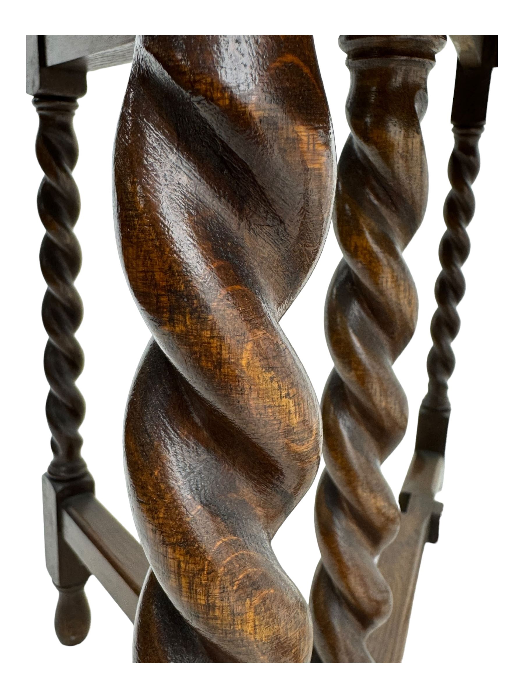 Early 20th century oak gateleg table, oval top with drop leaves supported by barley twist swing supports, united by plain stretchers, on turned feet (W119cm, D92cm, H77cm);