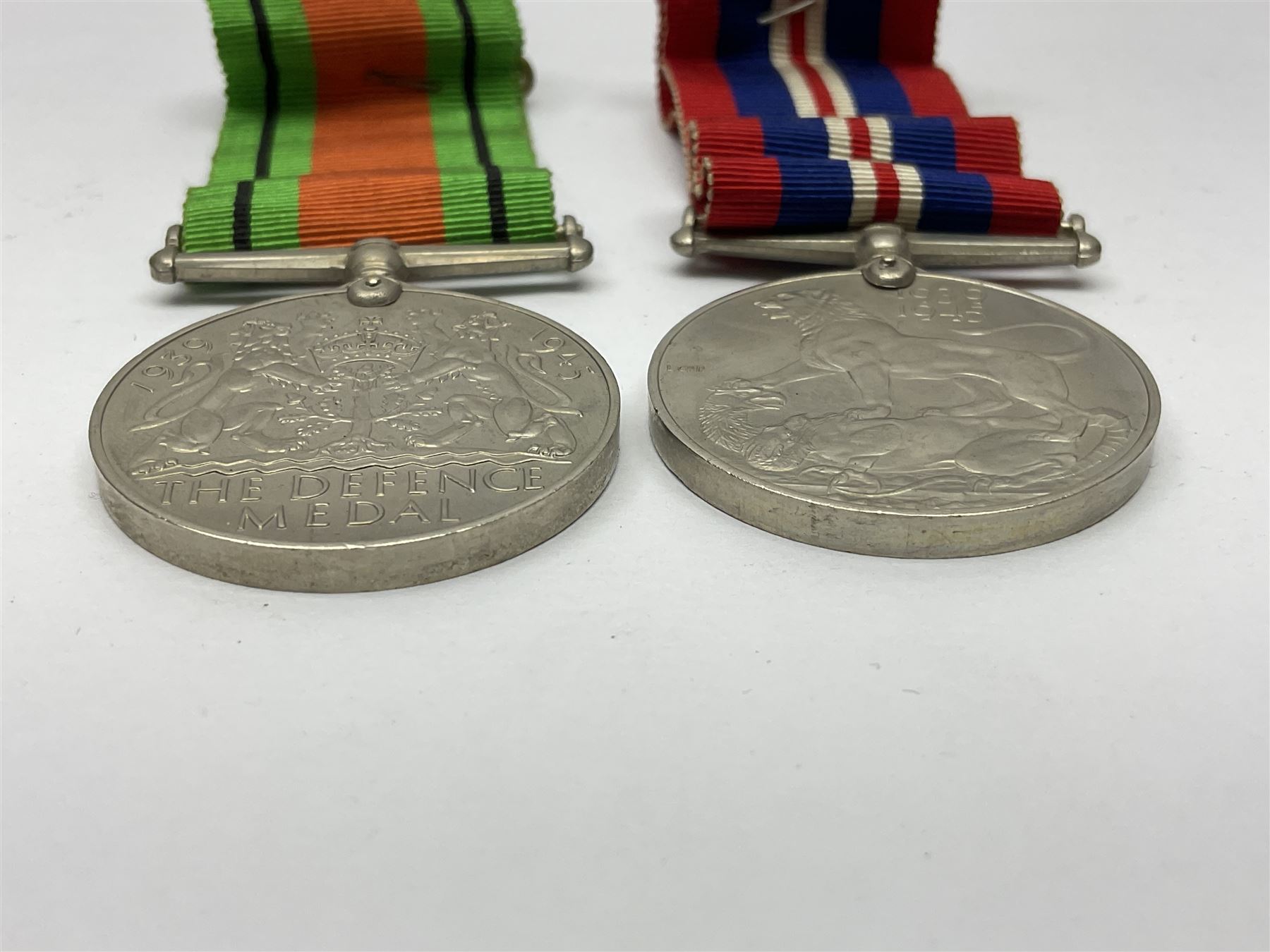 WW1 pair of medals awarded to 151761 Gnr. S. Loten R.A. with ribbons; four WW2 medals with ribbons; and small quantity of cap badges, medallions etc