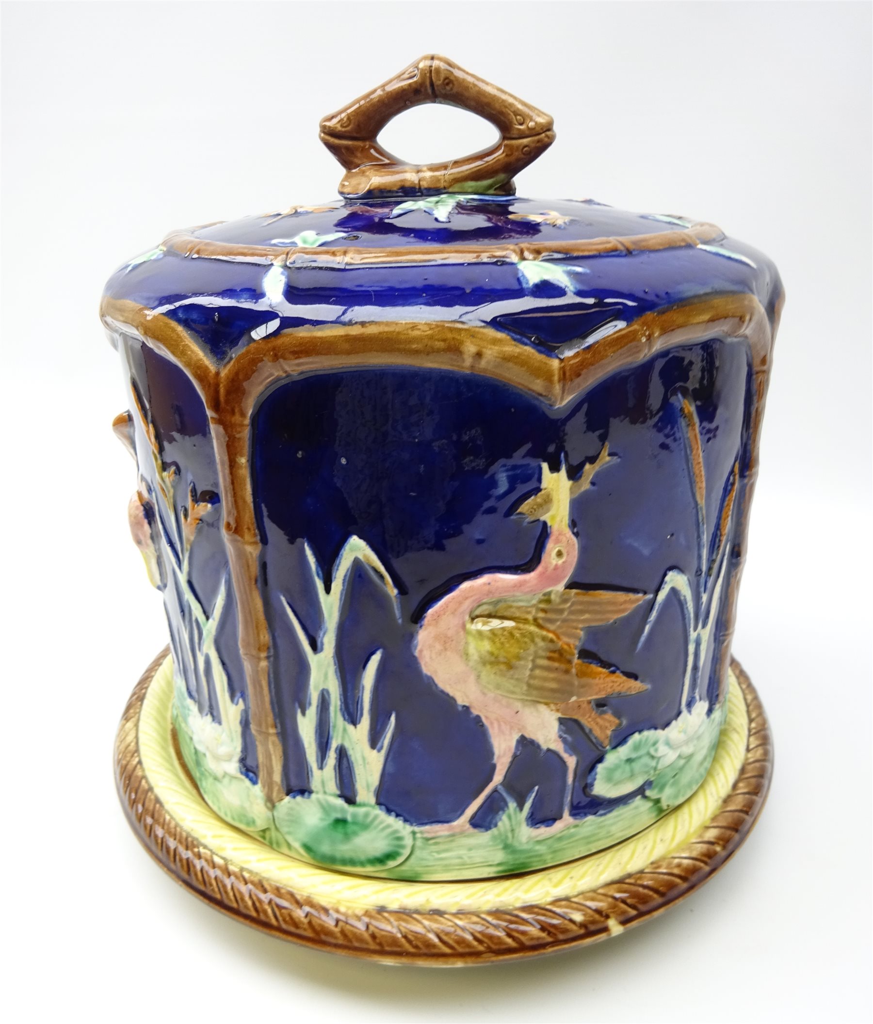 Victorian Majolica cheese dome on circular stand, decorated in relief with Cranes feeding