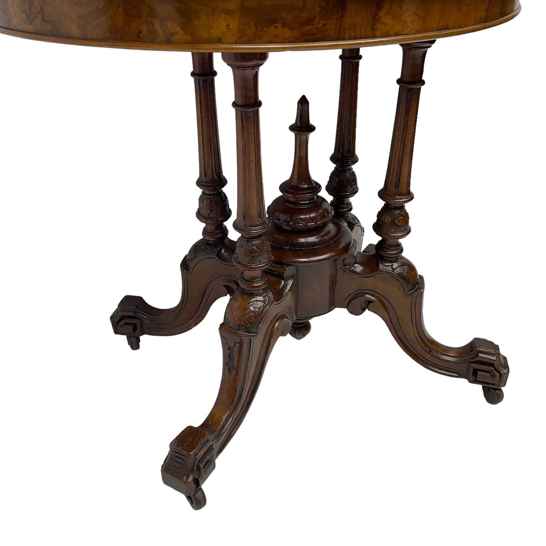 Victorian figured walnut demi-dune card table, the fold-over moulded top with circular baize lining, on four turned pillars with central finial platform, four splayed moulded supports with angular scrolled feet, on castors