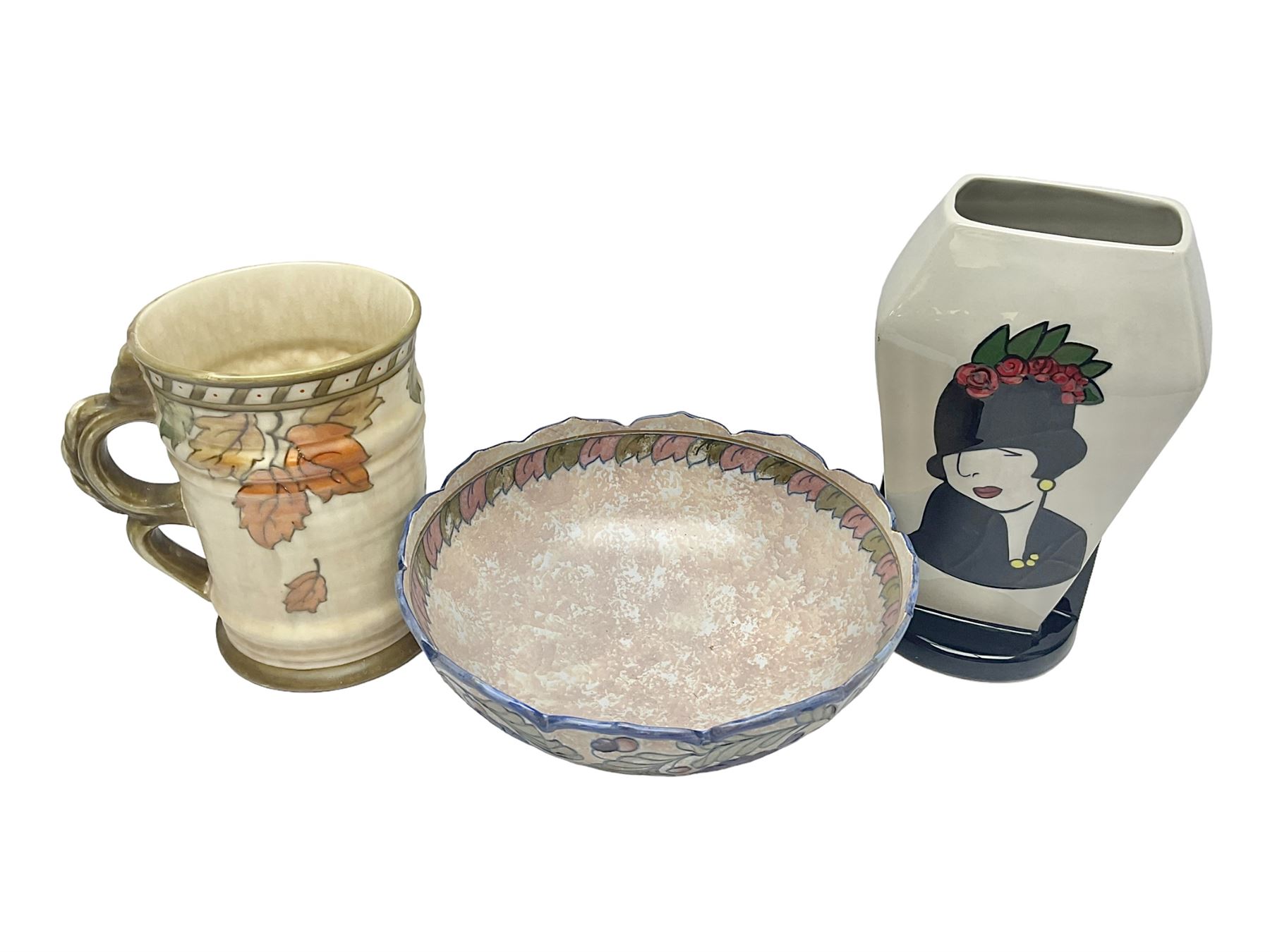 Charlotte Rhead for Crown Ducal ceramics, comprising coffin shaped vase depicting a woman in 1920s dress, a vase with handle, decorated with autumn leaves and a bowl, decorated with flowers and berries, with printed and signed marks beneath, coffin vase H24cm