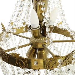 Empire design brass and crystal chandelier, the two circular brass tiers with foliate mounts, connecting the cascading crystal garlands, with prismatic drops